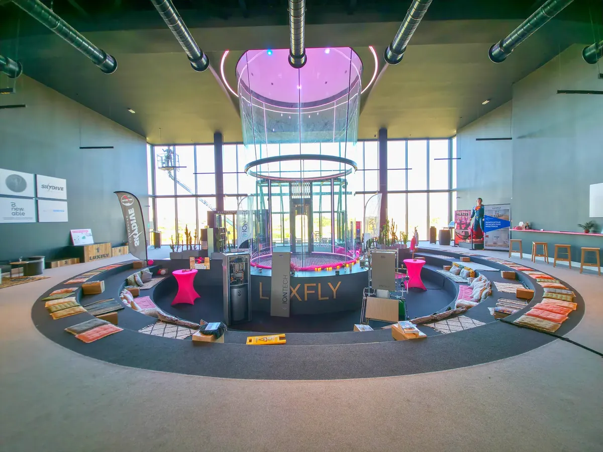 Le hall de Luxfly en journée : la soufflerie au centre, entourée de gradins circulaires